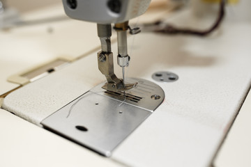 Closeup sewing machine needle. Tailor industry. dress manufacturing industry