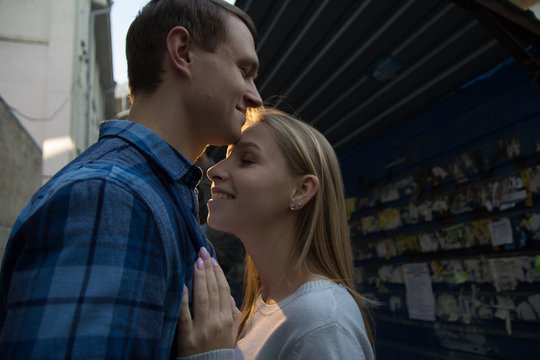 happy smiling couple hugging on the street against the wall with ads, dating by advertisement,dating site