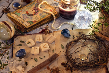 Open diary book with runes, dried herbs and tarot cards on table. Magic gothic ritual. Wicca,...