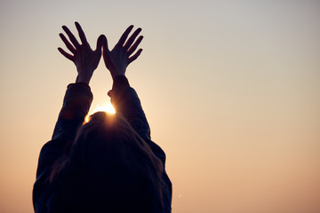 Woman with arms wide open enjoying the sunrise / sunset time.