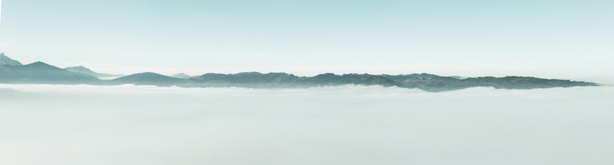 panoramic view of swiss alps over clouds cover