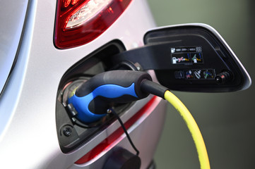Charging an electric car with the power cable supply plugged in