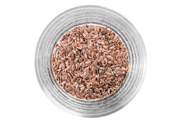 Flax seeds in a glass cup on a white background, top view