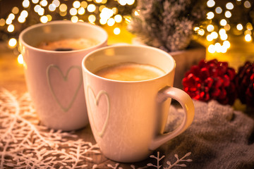 Two cups of hot coffee with party lights