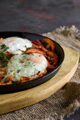 Fried eggs with bacon, bell pepper and tomato