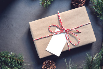Christmas gift box with note card and tree branch decor on marble background. Flat lay, Top view with copy space