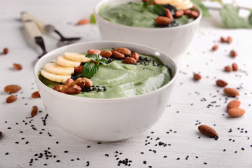 Bowls with tasty spirulina smoothie on white table