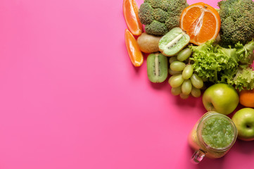 Mason jar of tasty green smoothie and ingredients on color background