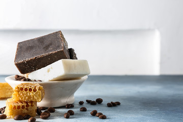 Soap bars with coffee beans and honeycombs on color table