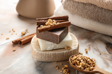 Soap bars with cinnamon sticks on color table
