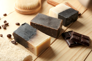 Soap bars with chocolate pieces on wooden table