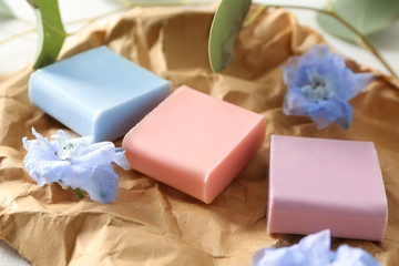 Different soap bars with flowers on crumpled paper