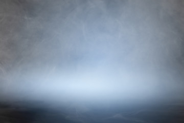 Smoke or mist or fog over dark background. Abstract background.