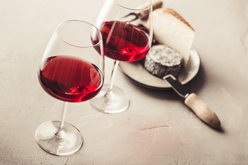 Red wine and cheese on concrete background