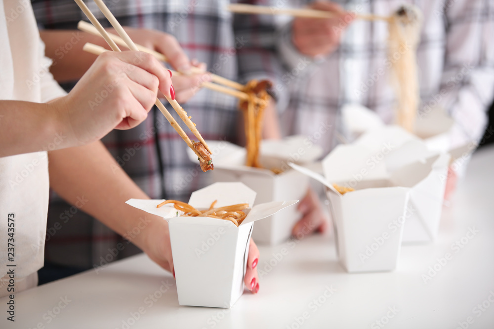 Wall mural people eating chinese noodles from takeaway boxes, closeup