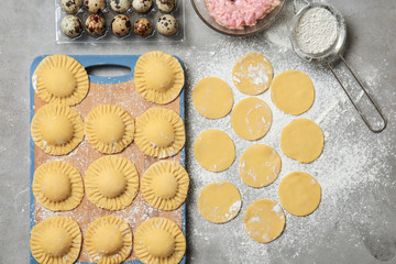 Raw ravioli and ingredients on table, top view