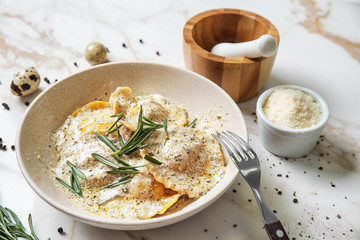 Plate with tasty ravioli on marble table