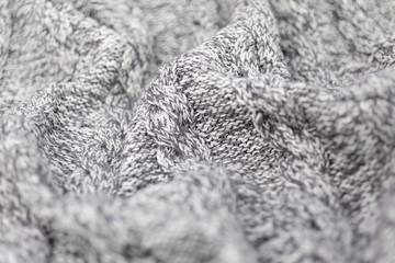 Knitted grey fabric texture with a relief pattern . Warm winter clothes or blanket. Handmade texture