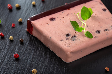 Pate specialty made from pork and turkey liver with sweet cranberry jam on a dark slate