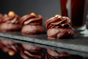  Chocolate dessert with hazelnut and coffee with cream on a black background.
