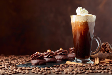  Chocolate dessert with hazelnut and coffee with cream on a wooden table.