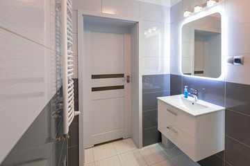 New bathroom interior with illuminated mirror - obrazy, fototapety, plakaty