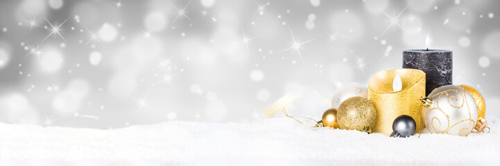 Christmas background - candle and decorations in snow on blurred background.