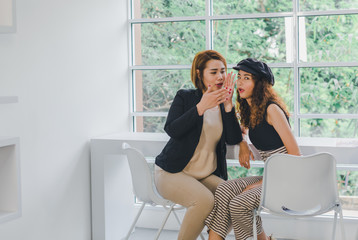 Portrait of asian businesswoman sit on a white chair and smile in the office.