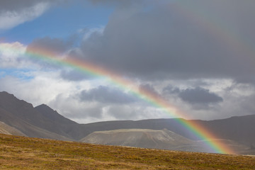 A look from Iceland, when rain falls, a rainbow forms. In the background is the volcanic mountain range.