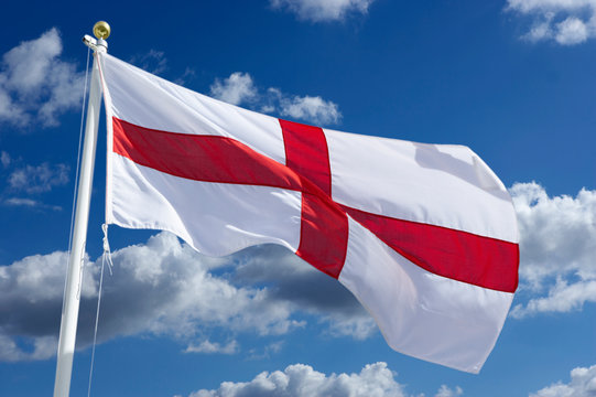 ENGLISH RED AND WHITE CROSS OF SAINT GEORGE FLAG WITH BLUE SKY AND WHITE CLOUDS