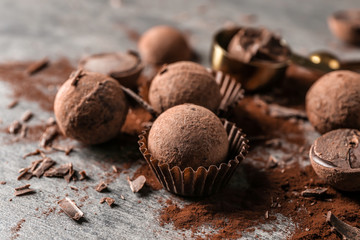 Tasty chocolate truffles with cacao powder on grey table