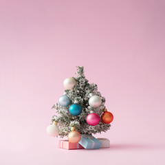 Colorful Christmas tree on pastel pink. Minimal New Year concept.
