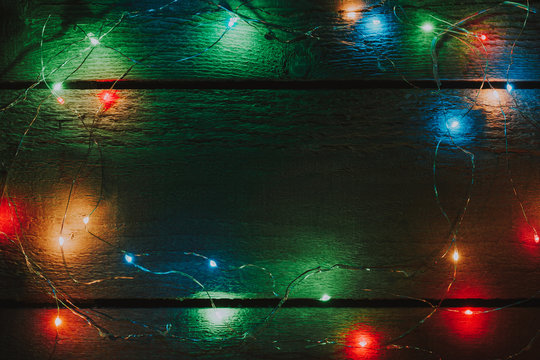Christmas tree lights decoration on bright wooden background with creative copy space. © Zamurovic Brothers