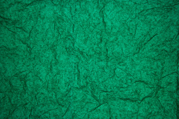 ABSTRACT RANDOM BACKGROUND OF CREASED CRUMPLED DARK EMERALD GREEN TISSUE PAPER