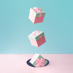 Pastel pink Christmas gift boxes on blue and pink backdrop. New Year present concept. Minimal...