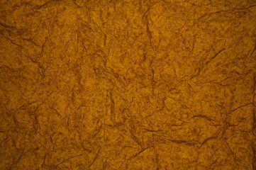 ABSTRACT RANDOM BACKGROUND OF CREASED CRUMPLED DARK ORANGE TISSUE PAPER