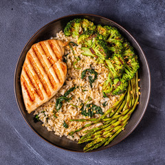 Obraz na płótnie Canvas Grilled chicken breast with brown rice, spinach, broccoli, asparagus