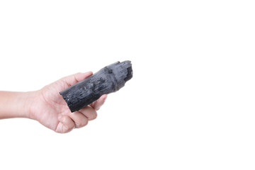 Obraz premium Hand holding natural black wood charcoal made of bamboo use for fuel or absorb bad smell