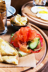 Omelette with vegetables and bread on wooden table in the restaurant. Tasty food. Gourmet