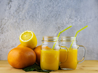 Plakat glass of orange juice and lemons on wooden table