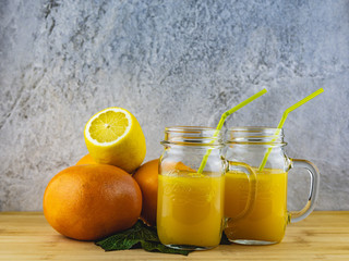 Fototapeta na wymiar glass of orange juice and lemons on wooden table