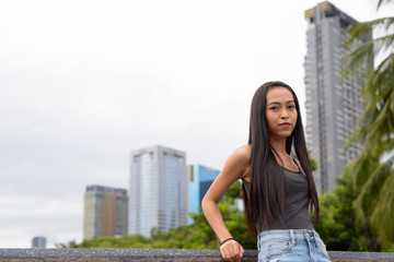 Young beautiful Asian woman relaxing at the park