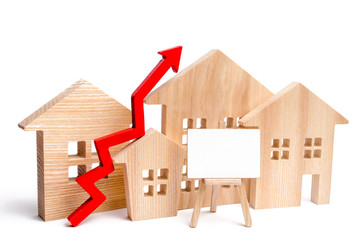 Wooden houses with a red arrow up and space for text. concept of high demand for real estate. Real...