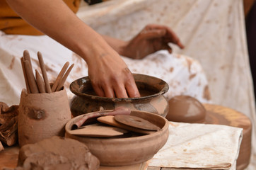 Close-up of female hand of medieval craftsman potter preparing clay - moistens and kneads the clay before work