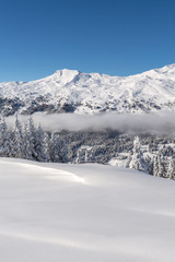 Verschneite Winterlandschaft mit Weitsicht auf die Alpen und aufkommenden Nebel - Parpaner Rothorn, Graubünden, Schweiz