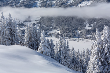 Verschneite Winterlandschaft mit Weitsicht auf die Alpen und aufkommenden Nebel - Parpaner Rothorn, Graubünden, Schweiz