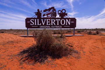 Silverton town welcome sign. Gateway to outback Australia with red desert sand and mulga bush. - obrazy, fototapety, plakaty