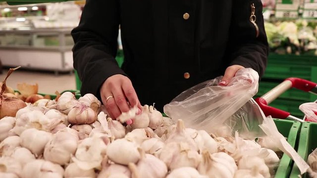 woman choose fresh garlic at the store, the concept of healthy food