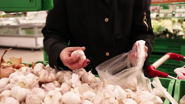 woman choose fresh garlic at the store, the concept of healthy food