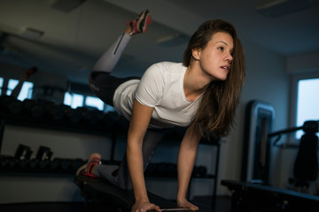 Fototapeta na wymiar Young woman doing exercises in the gym